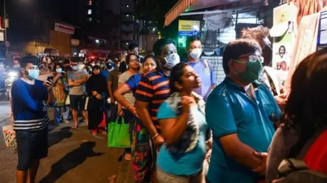 মুম্বাই শহরে বহু মানুষ জিনিসপত্র কিনতে দোকানের সামনে ভিড় করেছে।