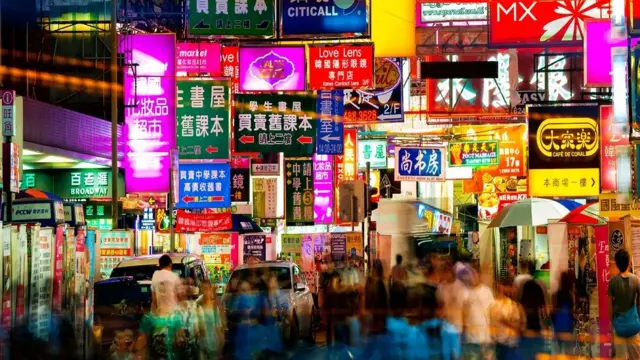 Papan nama neon di Hong Kong dengan tulisan bahasa China dan Inggris.