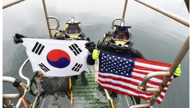 2021년 6월 15일 경남 창원 진해만 일대에서 열린 한미 연합 구조전 훈련에서 양국 구조대원들이 손상 함정 긴급 복구 훈련 종료 후 자국 국기를 들어보이고 있다