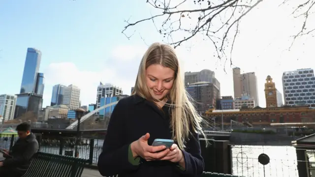Mujer y hombre ven sus celulares y ni se prestan atención.