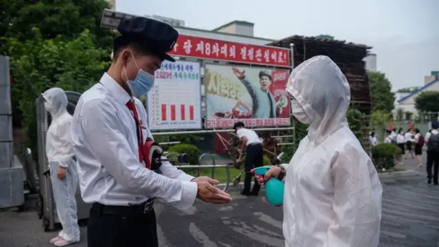 장철구평양상업대학의 한 학생이 캠퍼스에 들어가기전에 손에 손 소독제를 받는 모습