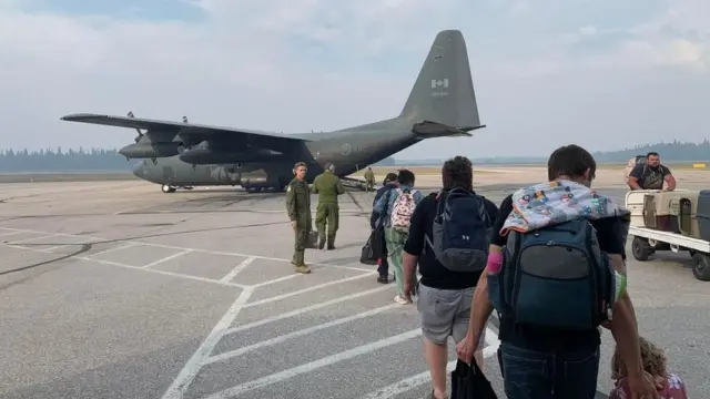 Photo of evacuees being loaded on Canadian military plane to evacuate out of Hay River