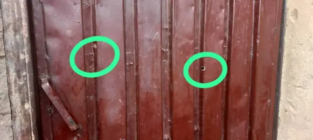 La porte de la maison de Muhammad Hussaini où l'on peut voir l'impact de balle