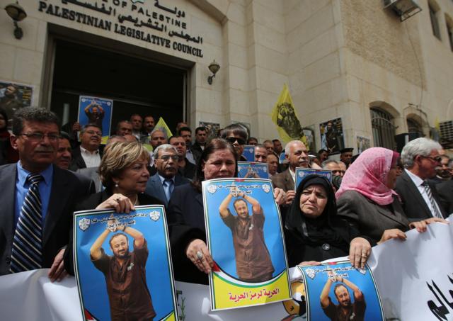 Fadwa Barghouti and other protesters holding placard bearing marwan barghouti's portrait, during a march on 15 April 2015 to mark the anniversary of his arrest and demand his release from Israeli prison