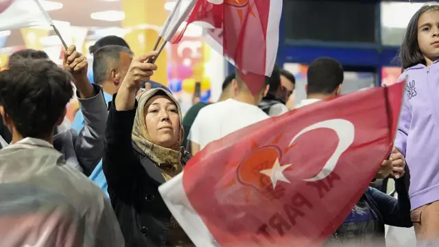 başörtülü bir kadın, elinde türk bayrağı ve akp bayrağıyla seçim sonucunu kutluyor, Gaziantep, 28 Mayıs 2023. 