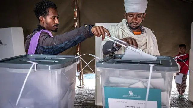 Onye na-atụ vootu ya dịka onye ọrụ National Election Board of Ethiopia (NEBE) na-enyere ya aka n'ọdọ ntuliaka Beshale Katla dị na Addis Ababa, na June 1, 2026,