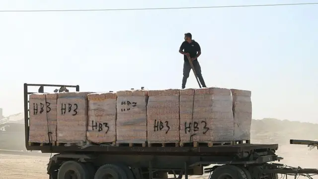 ग़ज़ा में घुस रहे सहायता सामग्री के ट्रक की निग़रानी करता हमास का लड़ाका