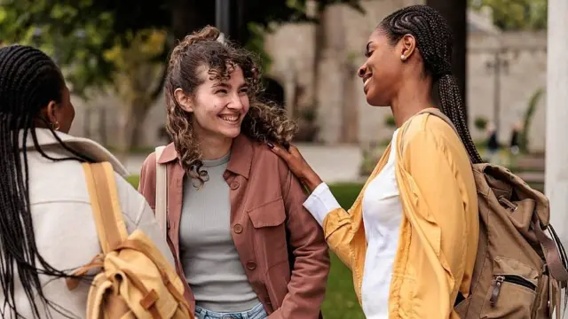 Três adolescentes conversando ao ar livre