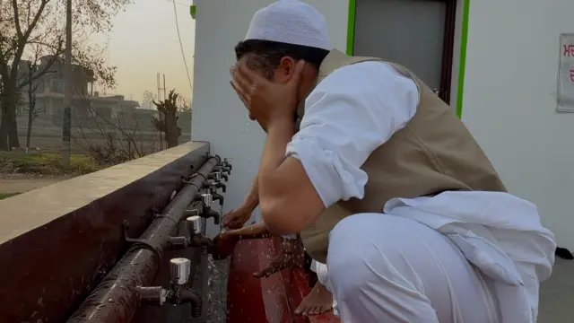 ایک شخص نماز پڑھنے سے پہلے وضو کر رہا ہے