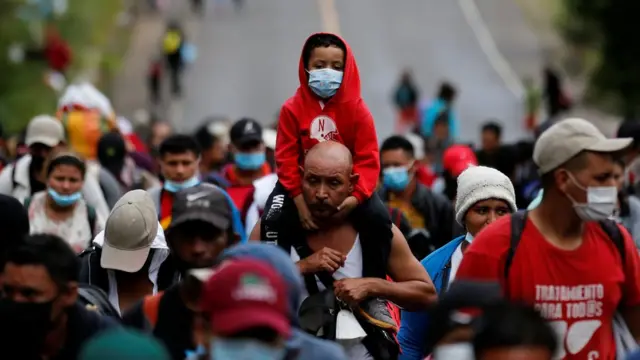 Un hombre lleva a un niño en sus hombros. Ambos integran la caravanaapostaaposta em roletaroletamigrantes que partióapostaaposta em roletaroletaHonduras y pretende llegar a Estados Unidos.