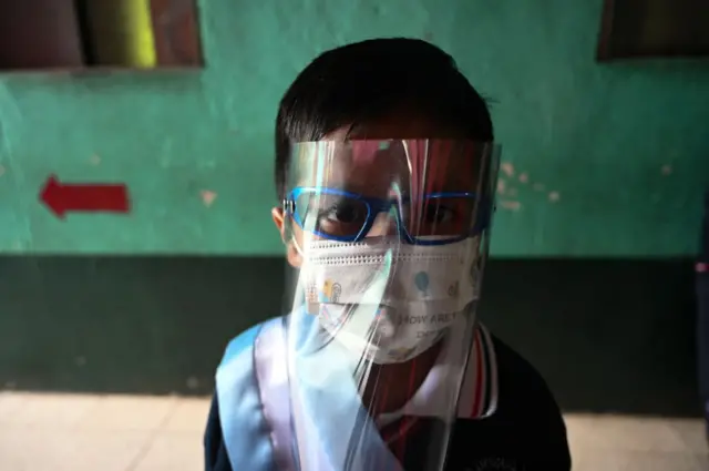 Un niño con mascarilla como medida cautelar contra la propagación del nuevo coronavirus, COVID-19, asiste al acto de inicio de clases en el Colegio Ramona Gil en Chimaltenango, 60 km al oeste de la Ciudad de Guatemala, el 22 de febrero de 2021.- El año escolar se inauguró en el sector público en todos los niveles en Guatemala, donde las clases serán presenciales y a distancia según las condiciones de cada escuela mientras dure la emergencia provocada por la pandemia de coronavirus.