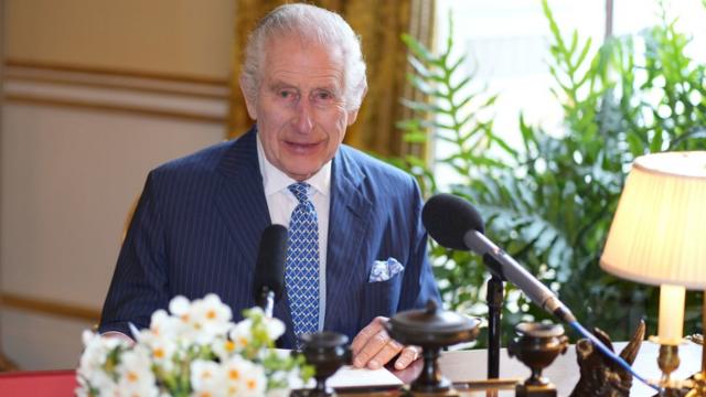 King Charles sitting at a desk recording his Maundy message