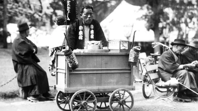 Fotobetmotion logopreto e branco mostra ambulante com carrocinha na rua