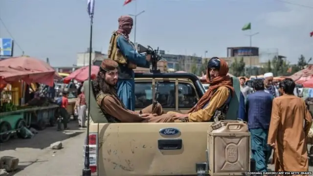 राजधानी काबुल के कोटे सांगी इलाक़े में बाज़ार में पिक-अप ट्रक पर घूमते तालिबान लड़ाके