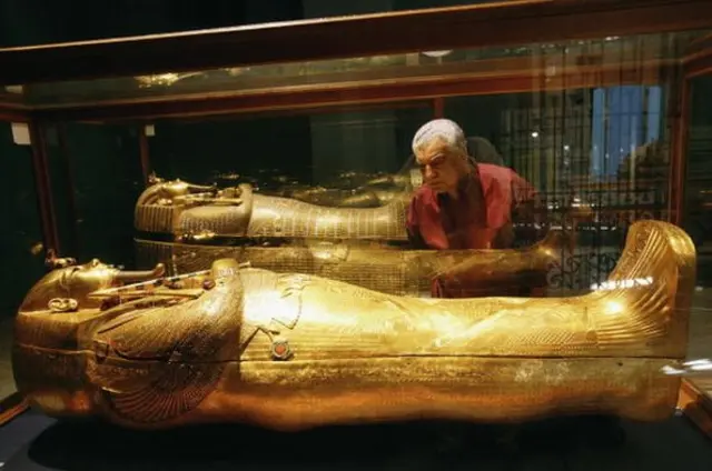Le Dr Hawass regarde le sarcophage de Toutankhamon.
