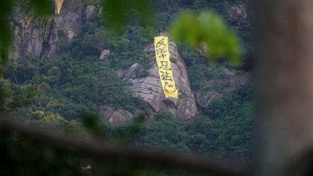 有人在山头挂上直幡，抗议修订《逃犯条例》。