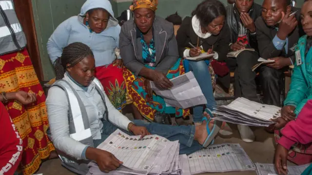 Les personnes qui regardent le décompte des votes