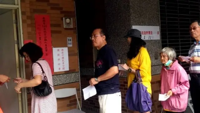 四年前的九合一地方选举,选民们在票站外排队。