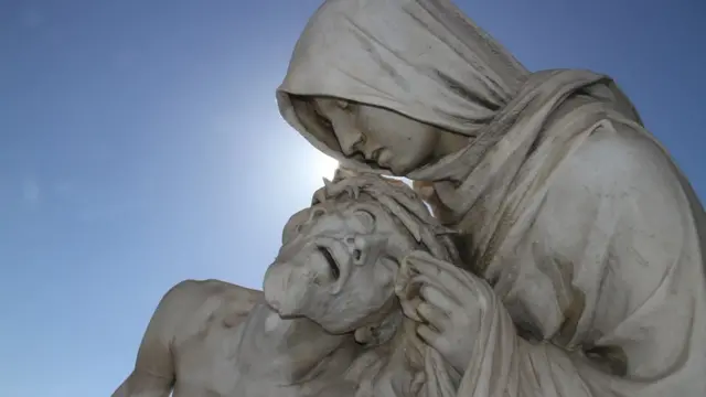Gros plan de la statue de la Pieta dans un ciel bleu clair