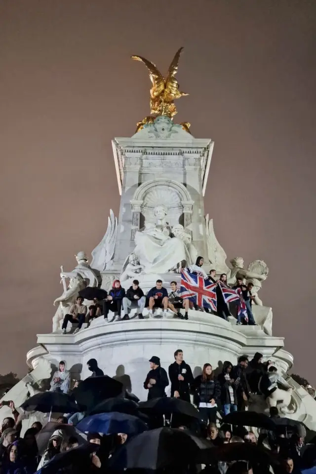 Las banderas son desplegadas por la multitud en el Queen Victoria Memorial