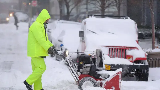 pria sedang membersihkan salju
