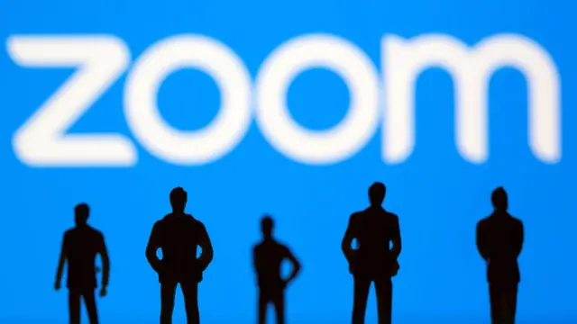 Силуэты людей на фоне логотипа Zoom