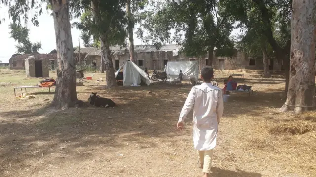 चक्रोही गांव में असलम अपने टेंट की ओर जाते हुए