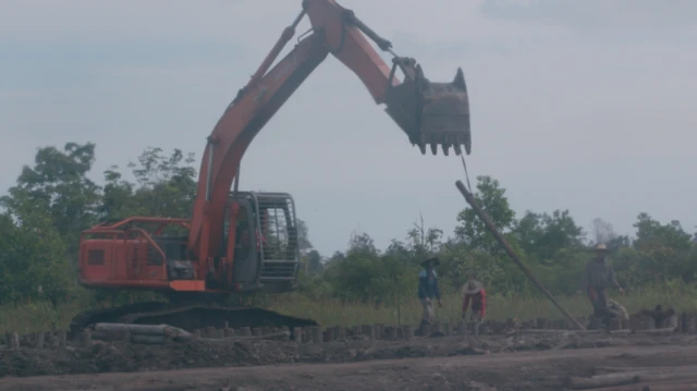 BBC witnesses workers using heavy equipment digging out land near the canal and making the foundations of a building.