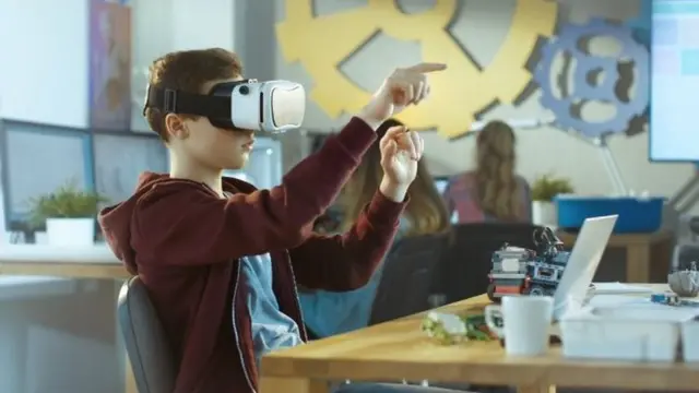 A boy wearing a VR headset in a classroom