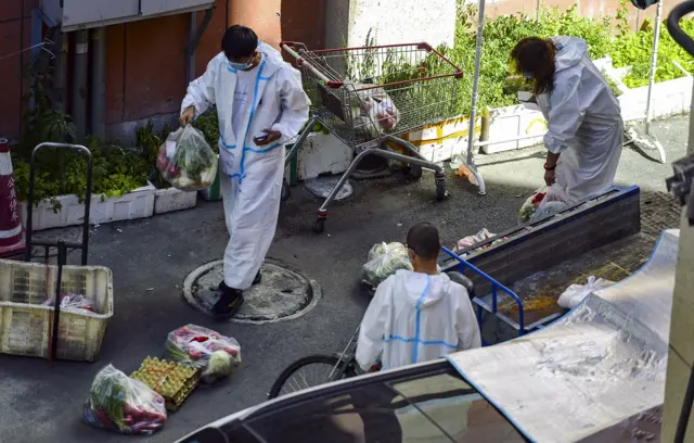 乌鲁木齐的市民被禁止外出，他们的生活必需品由社区工作人员和志愿者配送。