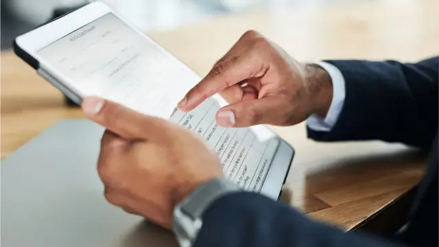 Mão masculina preenchendo formulário no tablet