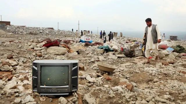 An Afghan man looks for his belongings following the floods