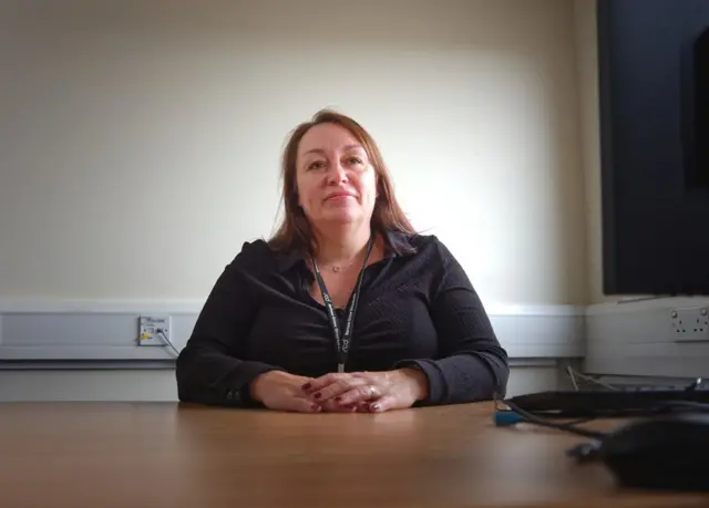 Michelle McHugh, the deputy bureau manager, sitting in front of a desk