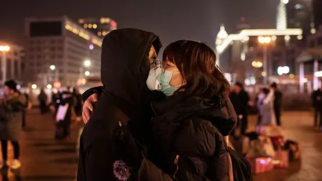 Pareja con mascarillas besándose