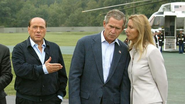 Джордж Буш слушает переводчика в то время, как Сильвио Берлускони общается с прессой по своему прибытии в Кэмп-Дэвид, 14 сентября 2002 года