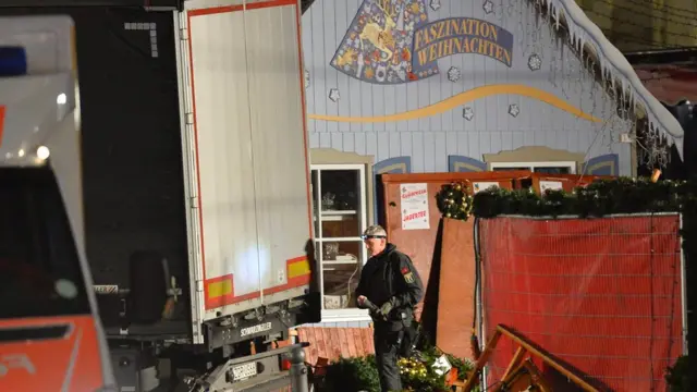 Police officer inspects scene of truck crash in Berlin on 19 December 2016