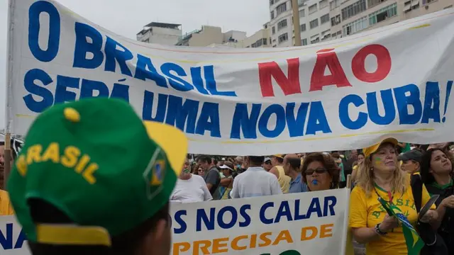 Manifestantes brasileiros com cartaz crítico a Cuba