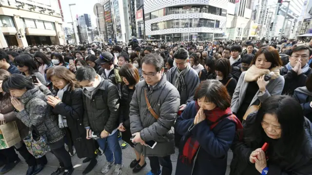 People observe a moment of silence in Tokyo's Ginza shopping district at 2:46 p.m. on March 11, 2017, the sixth anniversary of the earthquake, tsunami and nuclear disasters in northeastern Japan.