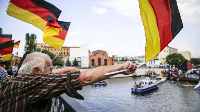 An AfD protester in Berlin waves a German flag