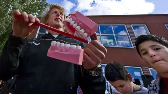 Professor ensinando a escovar os dentes