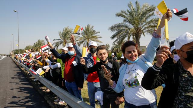 بغداد - مستقبلون عراقيون يرفعون أعلام العراق والفاتيكان بانتظار وصول البابا إلى مطار بغداد