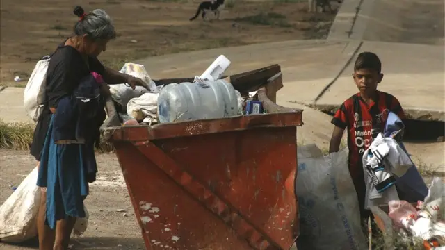 Madre en Venezuela busca en la basura con su hijo