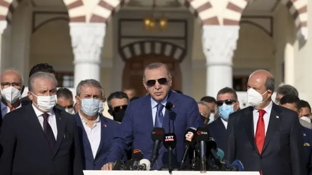 Turkish President Recep Tayyip Erdogan (C) makes a statement after performing Eid al-Adha prayer with Turkish Cypriot President Ersin Tatar (R) at Hala Sultan Mosque prayer on July 20, 2021. (Photo by Ercin Erturk/Anadolu Agency via Getty Images)