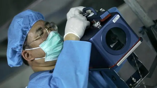 یکی از کارکنان آژانس بین‌المللی انرژی اتمی در حال نصب یکی از دوربین‌های این نهاد در تاسیسات هسته‌ای اصفهان در سال ۲۰۰۵