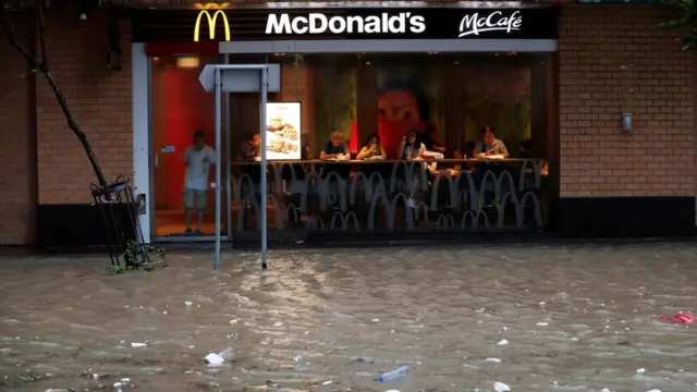 香港杏花邨一家麥當勞餐廳顧客觀看店外被淹沒的馬路(23/8/2017)