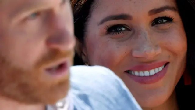 Harry y Meghan de fondo