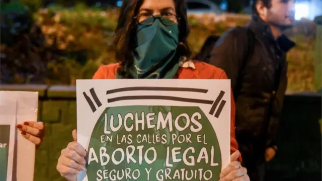 Una mujer sostiene una pancarta: "Luchemos en las calles por el aborto legal, seguro y gratuito".