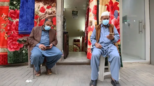 কুয়েত সিটিতে মাস্ক পরে দুই দোকানি