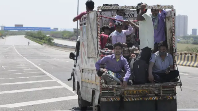 trabalhadores migrantes no fundoaposta no jogo de futebolum carroaposta no jogo de futebolNoida, India