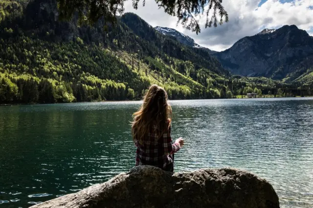 A girl looks out over Lake Langbathsee, Austria